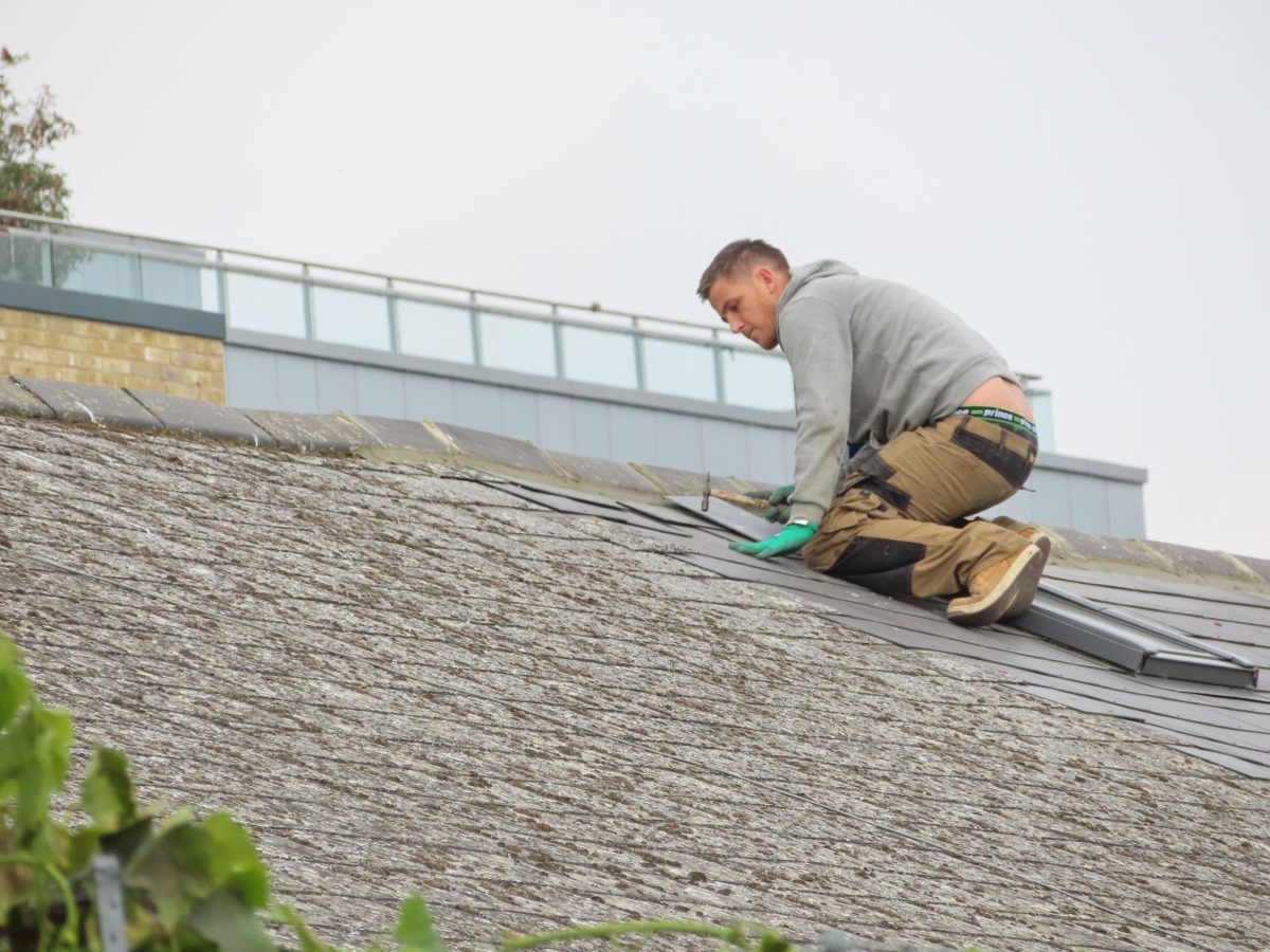 Dachdeckermeister bei der Montage von Dachziegeln