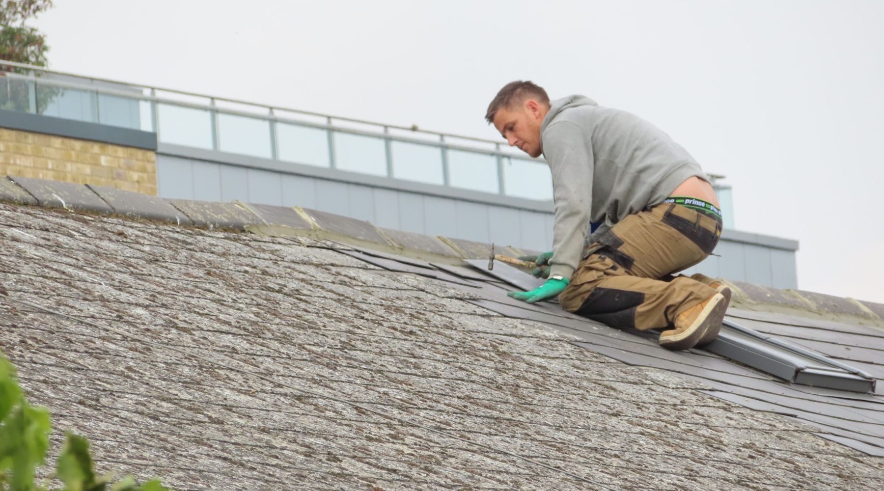 Dachdeckermeister bei der Montage von Dachziegeln